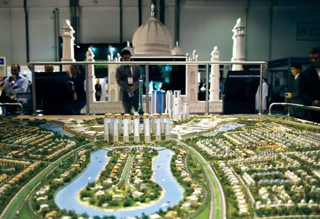 Visitors look at the Falcon city model during the Cityscape real estate exhibition in Dubai