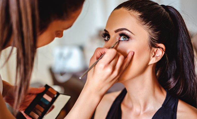 Makeup artist applying eyeshadow on a girl